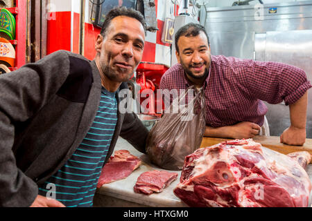 Fes, Marokko.  Marokkanische Metzger und seinen Kunden, Talaa Kebira-Straße in der Altstadt. Stockfoto