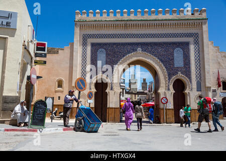 Fes, Marokko.  Backpackers rechts in die Altstadt (Fes El-Bali) durch die Bab Boujeloud.  Das Minarett der Medersa Bou Inania ist in der ba Stockfoto