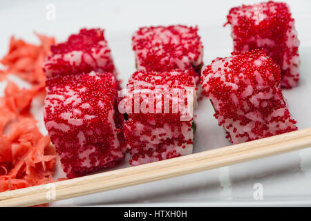 Schläger aus Reis mit rotem Fischrogen, mariniertem Ingwer und Holzstäbchen Stockfoto