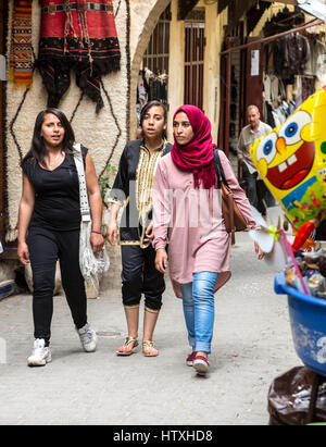 Fes, Marokko.  Junge marokkanische Frauen gehen in der Medina, Tala'a Seghira Street, Fes El-Bali.  Moderne Kleidungsstil. Stockfoto