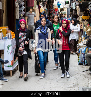 Fes, Marokko.  Junge marokkanische Frauen gehen in der Medina, Tala'a Seghira Street, Fes El-Bali.  Moderne Kleidungsstil. Stockfoto