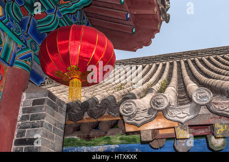 China, das Shaolin-Kloster. Helle farbige Laterne hergestellt aus Naturseide in China vor dem Hintergrund des Daches einer der Hallen. Stockfoto