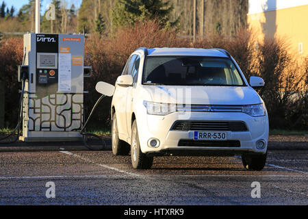 PAIMIO, Finnland - 5. Dezember 2016: Mitsubishi Outlander-Plug-in Hybrid SUV Batterie aufladen. Auf dem Markt seit 2013 war der Outlander P-HEV die fi Stockfoto