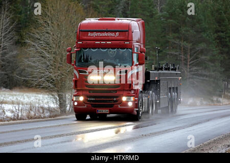 SALO, Finnland - 2. Dezember 2016: Rot Scania R560 V8 Lkw der Kuljetus Pertti J. Leino Oy auf nasser Fahrbahn mit Streusalz im Schneefall. Der Fahrer blinkt t Stockfoto