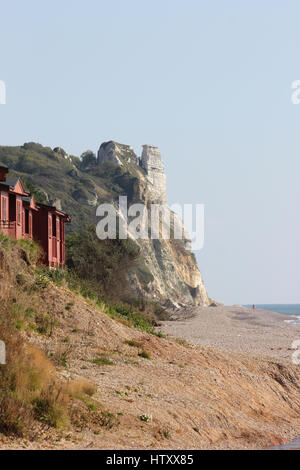 Strandhütten und die Klippen zwischen Branscombe und Bier Kopf, Devon, Blick nach Osten vom Branscombe Strand an einem sonnigen Tag mit blauem Himmel Stockfoto