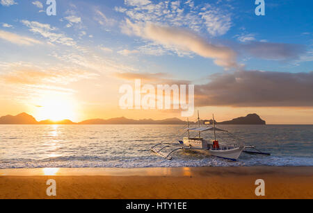 Traditionelle Banca Boot bei Sonnenuntergang auf Ipil-Ipil Beach in der Nähe von El Nido, Palawan Island, Philippinen Stockfoto