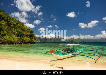 Traditionelle Banca Boot in klarem Wasser am Strand in der Nähe von Cudugnon Höhle, El Nido, Palawan Island, Philippinen Stockfoto