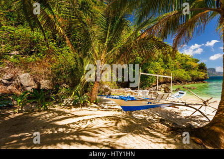 Traditionelle Banca Boot im Schatten am Strand in der Nähe von Cudugnon Höhle, El Nido, Palawan Island, Philippinen Stockfoto