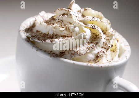Weiße Tasse Kaffee mit Sahne obenauf Stockfoto