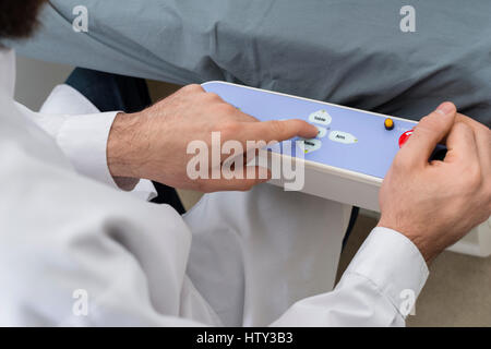 Arzt über die Systemsteuerung des Bettes im Krankenhaus Stockfoto