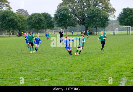 Jungs spielen Fußball in einem Park am Samstagmorgen UK KATHY DEWITT Stockfoto