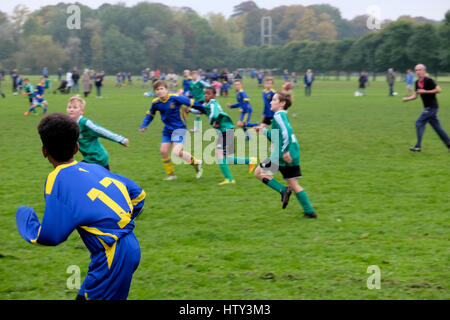 Jungen Kindermannschaften, die an einem Samstagmorgen in Großbritannien, KATHY DEWITT, Teamfußball im Park spielen Stockfoto