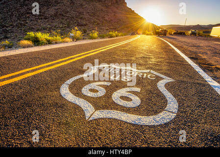 Straßenschild auf der historischen Route 66 in der Mojave-Wüste bei Sonnenuntergang gegen die Sonne fotografiert Stockfoto