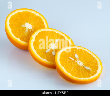 Drei Ringe geschnittenen saftige Reife Orange auf einem hellblauen Hintergrund. Stockfoto