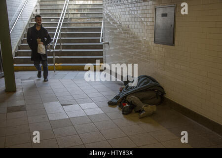 Mann schläft im Eingang der U-Bahn-Station in Manhattan, NYC. Stockfoto