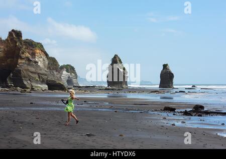 Frau tanzt am Strand von Three Sisters and Elephant Rock, Nordinsel, Neuseeland Stockfoto