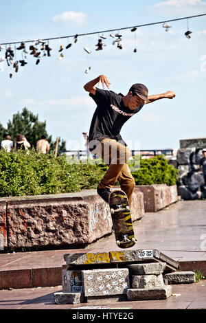 Ein Kerl ist an das Prager Metronom in Letna Park, Tschechien skateboarding. Stockfoto