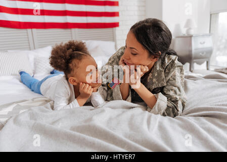 Gut aussehende positive Damen entspannend im Schlafzimmer Stockfoto