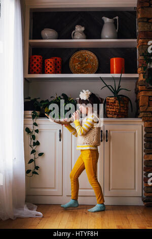 Mädchen stehen vor Fenster weht ein horn Stockfoto