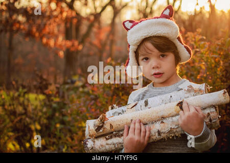 Junge mit Brennholz Stockfoto