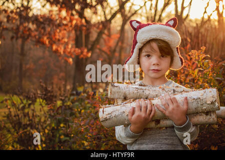 Junge mit Brennholz Stockfoto