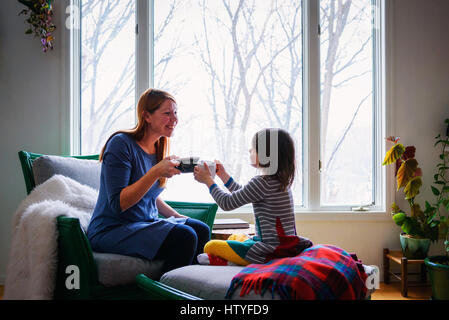Mutter und Tochter Toasten mit Tasse Tee Stockfoto
