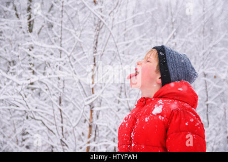 Junge Schneeflocken in den Mund zu fangen Stockfoto