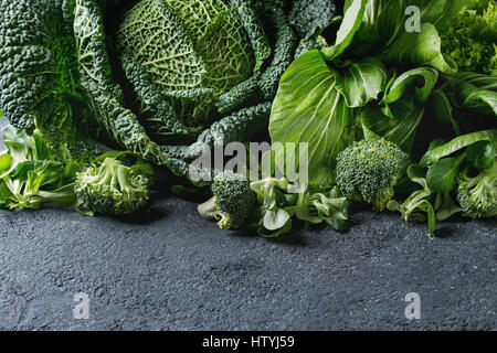 Vielzahl von rohem Gemüse Salate, Salat, Chinakohl, Mais, Brokkoli, Wirsing als Frame über schwarze Steinstruktur Hintergrund. Platz für text Stockfoto