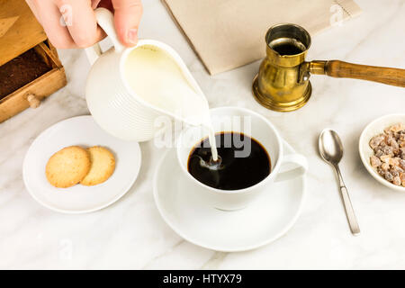 Milch in die Tasse gegossen Stockfoto