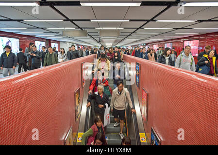 Massen von Pendler und Menschen vor Ort auf der Rolltreppe des Systems der MTR in Hong Kong. Stockfoto