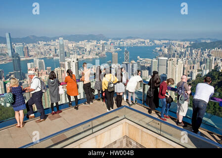 Touristen fotografieren von Sky Terrasse 428 auf den Peak Tower über Hong Kong und Victoria Bay an einem klaren sonnigen Tag mit blauem Himmel. Stockfoto