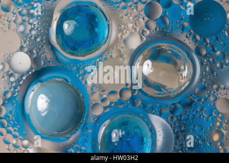 Blaue Perlen und Blasen in das ölhaltige Wasser Stockfoto