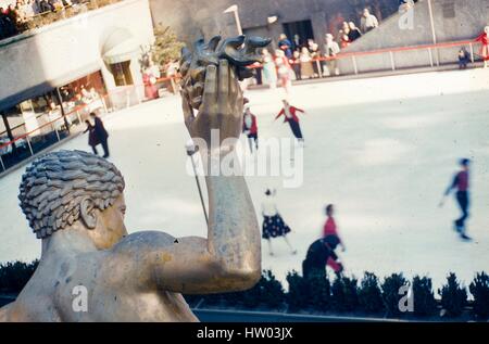 Detailansicht von hinten Paul Manship Prometheus-Statue, Rockefeller Center, Midtown Manhattan, New York City, 1957. Im Hintergrund unter die verwitterte Bronze verfolgen die Besucher zum Plaza Skater genießen die versunkene Eisbahn. Stockfoto