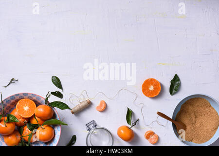 Frische orange Früchte mit Zucker, Zutaten für hausgemachte Marmelade. Ansicht von oben, Raum zu kopieren. Stockfoto