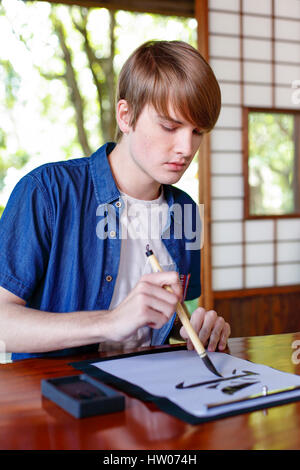 Kaukasischen Mann üben Kalligraphie im traditionellen japanischen Haus Stockfoto