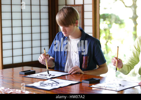 Kaukasischen Mann üben Kalligraphie im traditionellen japanischen Haus Stockfoto