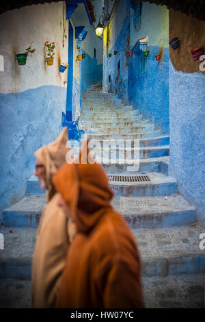 Mann mit einem traditionellen Kleid ist in der blauen Medina von Chefchaouen, Marokko Fuß. Stockfoto