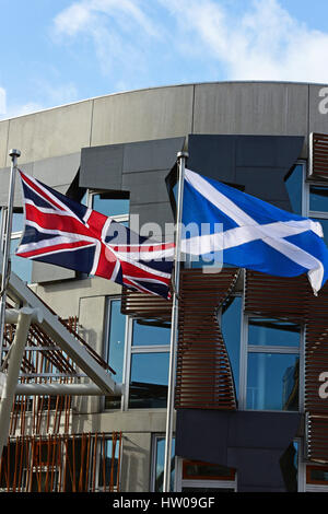 Edinburgh, Schottland. 14. März 2017. Anschluß-Markierungsfahne und die schottische Andreaskreuz fliegen außerhalb des schottischen Parlaments am Tag nach dem ersten Minister Nicola Sturgeon angekündigt wird sie Zustimmung um ein weiteres Referendum über die schottische Unabhängigkeit zu halten suchen. Credit: Ken Jack/Alamy Live-Nachrichten Stockfoto