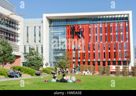 Studenten genießen Frühjahr Sonne außerhalb Birmingham City University im Bereich Eastside von Birmingham Stockfoto