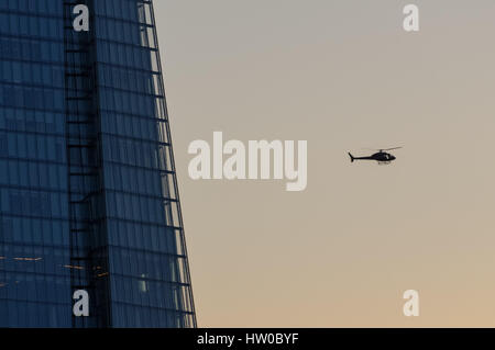 Polizei Hubschrauber fliegen neben dem Shard, London, England, Vereinigtes Königreich, Großbritannien Stockfoto