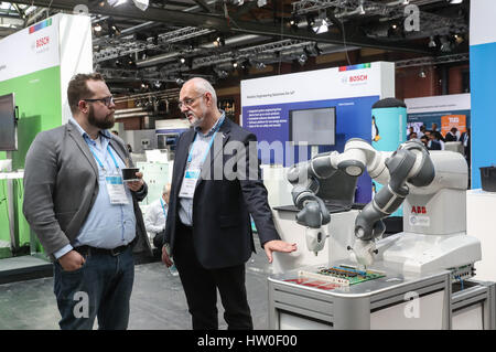 Berlin, Deutschland. 15. März 2017. Zwei Besucher sprechen vor einem Roboter während der Bosch ConnectedWorld 2017 in Berlin, Hauptstadt der Bundesrepublik Deutschland, 15. März 2017. Bosch ConnectedWorld 2017, gehalten vom 15. März bis 16, brachte mehr als 30.000 Führungskräfte und Entwickler Internet Things'(IoT) Trends und realen Implementierungen nach oben und unten Industrie Wertschöpfungsketten zu diskutieren. Während der Veranstaltung werden mehr als 80 Aussteller auch ihre erfolgreich umgesetzten IoT-Lösungen angezeigt. Bildnachweis: Shan Yuqi/Xinhua/Alamy Live-Nachrichten Stockfoto