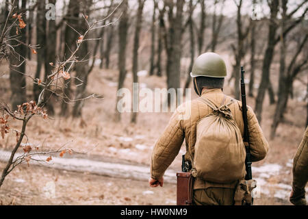 Re-Enactor gekleidet als sowjetischen russischen Roten Armee Infanterie Soldat des zweiten Weltkrieg marschieren auf Forststraße im Herbst Saison Stockfoto