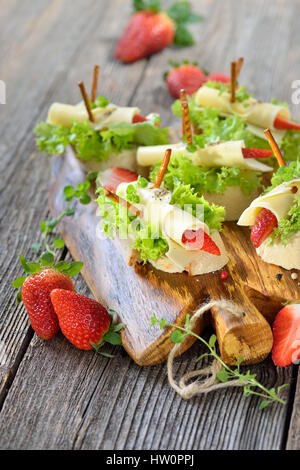 Kanapees mit leckeren Käsebrötchen und Erdbeeren auf italienische Ciabatta Brot mit Salatblättern Stockfoto