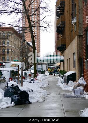 NYC Street Szene übermorgen Sturm Stella. Cleanup Crew Schaufeln Matsch und Haufen von schmutzigem Schnee. Müllsäcke. Upper Eastside, New York City, NY, USA Stockfoto