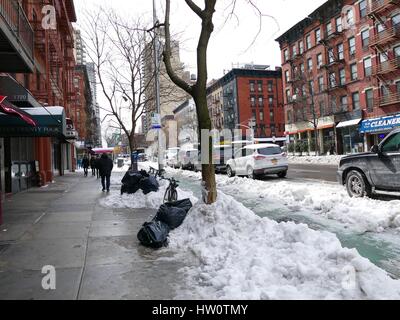 NYC Street übermorgen Sturm Stella. Fußgänger und Autos zu navigieren um Müll, Matsch und Haufen von schmutzigem Schnee. Upper Eastside, New York City, NY, USA Stockfoto