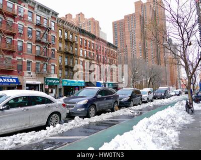 NYC Street Szene übermorgen Sturm Stella. Parkende Autos inmitten von Schneematsch und Haufen von schmutzigem Schnee. Upper Eastside, New York City, NY, USA Stockfoto