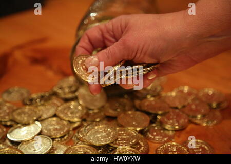 Senior weiblichen Hand nehmen Münze Glas Stockfoto