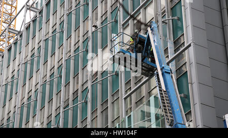 Männliche arbeiten hoch gelegenen Wolkenkratzer Stockfoto