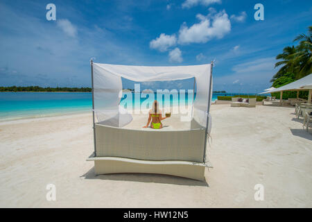 Maldives Rangali Island. Conrad Hilton Resort. Frau im Baldachin Stuhl am Strand. (MR)
