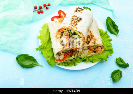 Döner - nahöstlichen Gericht von Lavash (Pita), gefüllt mit Hühnerfleisch, Champignons, Salat aus frischem Gemüse, Sauce. Stockfoto